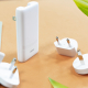Mise en situation du chargeur 65 W avec plusieurs adaptateurs de prises interchangeables disposés autour du produit.