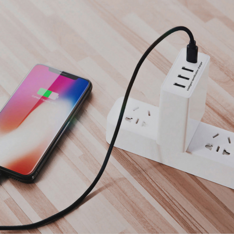 Chargeur alimentant un smartphone sur multiprise.