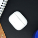 Boîtier de charge blanc fermé, présenté sur une surface sombre à proximité d’un carnet. Quatre indicateurs sont visibles sur la 