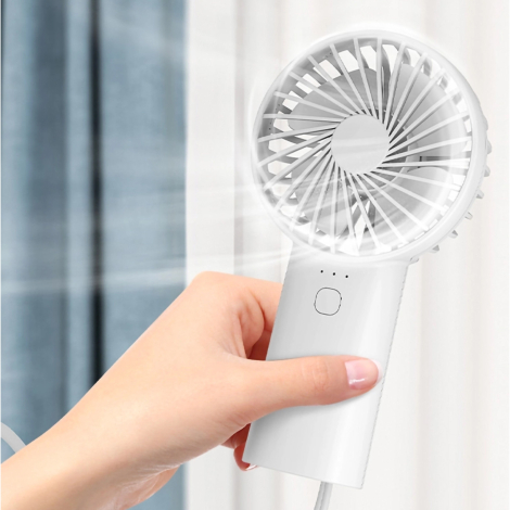 Ventilateur tenu à la main en fonctionnement, illustrant son utilisation comme ventilateur personnel portable.