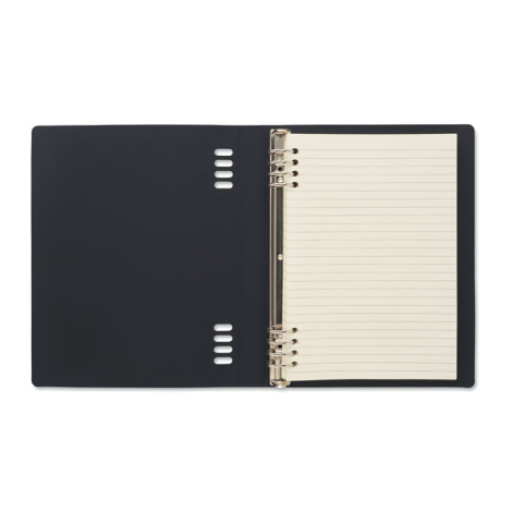 Intérieur du cahier ouvert sur une page lignée, montrant la couverture noire, la reliure métallique et les découpes qui permette