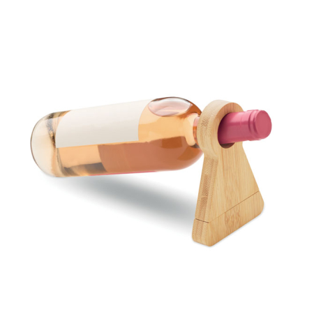 Une bouteille de vin est maintenue horizontalement par son goulot dans l’ouverture circulaire du support en bambou, posé vertica