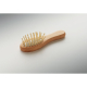 Gros plan sur la petite brosse en bois, avec manche arrondi et picots montés sur une base souple claire.
