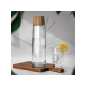 Bouteille en verre avec bouchon aspect bois posée sur une planche avec un verre d’eau citronnée. Bouteille en verre avec bouchon aspect bois posée sur une planche avec un verre d’eau citronnée.