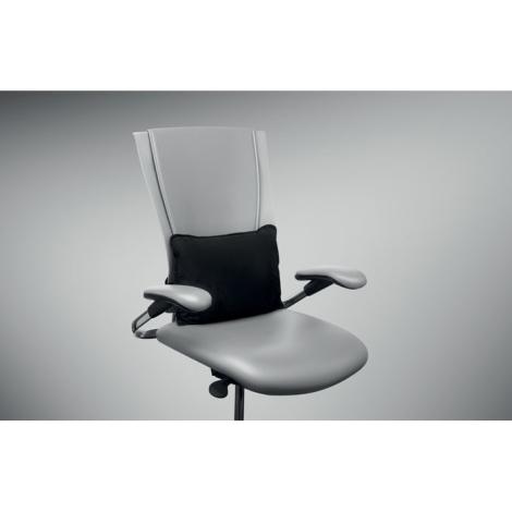 Coussin noir installé au niveau des lombaires sur le dossier d’une chaise de bureau.