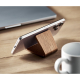Le support maintient un smartphone en position horizontale sur une table, à proximité d’une tasse et d’un ordinateur portable.