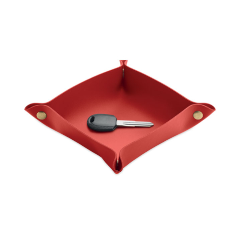 Vide-poches rouge utilisé pour déposer une clé de voiture, avec ses bords relevés et ses attaches métalliques visibles aux quatr