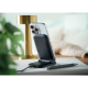 Posé sur un bureau, le chargeur noir maintient un smartphone verticalement sur son support incliné, à côté de deux stylos et d’u Posé sur un bureau, le chargeur noir maintient un smartphone verticalement sur son support incliné, à côté de deux stylos et d’u