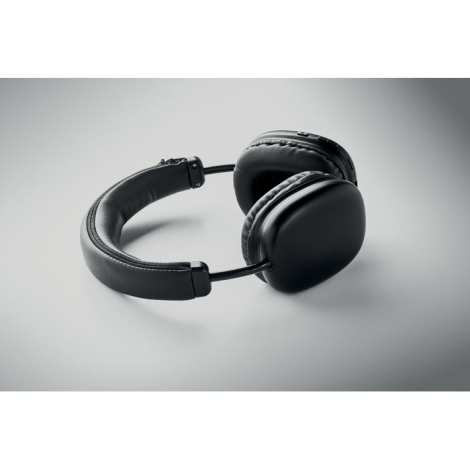 Casque audio noir posé à plat, montrant ses deux larges coussinets, son arceau rembourré et les commandes disposées sur une orei
