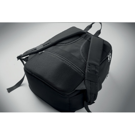 Gros plan sur le dos du sac à dos noir posé à plat, montrant les zones rembourrées en maille, les bretelles et la poche arrière 