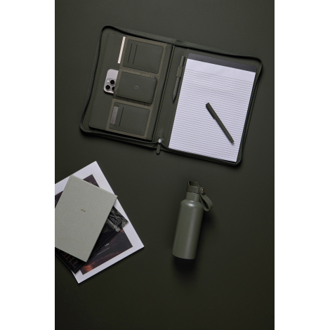 Porte-documents vert foncé ouvert avec bloc-notes ligné, stylo et plusieurs compartiments contenant un téléphone et des cartes, 