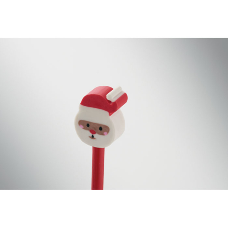 Gros plan sur la gomme Père Noël fixée à l’extrémité du crayon rouge, avec bonnet rouge et visage stylisé.
