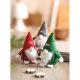 Trois lutins décoratifs rouge, vert et gris disposés sur une table dans une ambiance de fêtes, avec un marquage blanc visible su