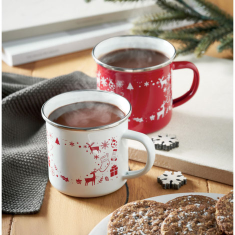 Mug blanc et mug rouge remplis d’une boisson chaude, disposés sur une table avec des biscuits et des décorations en forme de flo