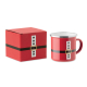 Mug rouge décoré à la manière d’une tenue de Père Noël, présenté à côté d’une boîte cadeau rouge assortie avec ceinture noire et Mug rouge décoré à la manière d’une tenue de Père Noël, présenté à côté d’une boîte cadeau rouge assortie avec ceinture noire et