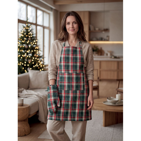 Femme portant le tablier à carreaux verts, rouges et blancs et tenant le gant de cuisine assorti, dans un intérieur décoré pour 