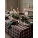 Nappe à carreaux verts, rouges et blancs dressée sur une table de fête avec vaisselle, verres, bougies allumées, feuillage décor Nappe à carreaux verts, rouges et blancs dressée sur une table de fête avec vaisselle, verres, bougies allumées, feuillage décor