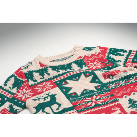 Gros plan sur le haut du pull de Noël à col rond beige et sur son tricot à motifs verts et rouges représentant notamment des sap