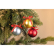Trois boules de Noël à finition satinée, argentée, dorée et rouge, ornées de nœuds en ruban rouge et suspendues aux branches d’u