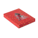 Vue en perspective d’une boîte cadeau rouge parsemée d’étoiles dorées, avec découpe en forme de sapin laissant apparaître plusie Vue en perspective d’une boîte cadeau rouge parsemée d’étoiles dorées, avec découpe en forme de sapin laissant apparaître plusie