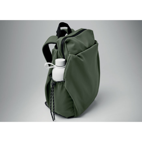 Vue de profil d’un sac à dos vert avec poche latérale contenant une bouteille blanche maintenue par un cordon de serrage, et gra