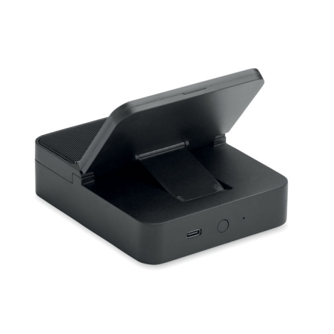 Vue arrière de l’enceinte noire avec support pour téléphone incliné, pied de maintien déployé, port USB-C et bouton rond visible