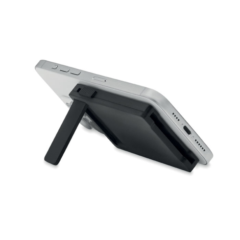 Vue de profil d’un smartphone posé en position inclinée grâce au support déplié du porte-cartes magnétique fixé au dos.