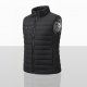 Vue de trois quarts d'un gilet chauffant noir sans manches, présentant son matelassage horizontal, son col montant zippé, une po Vue de trois quarts d'un gilet chauffant noir sans manches, présentant son matelassage horizontal, son col montant zippé, une po