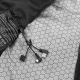 Gros plan sur la doublure intérieure à motif hexagonal gris et noir du gilet chauffant, avec une étiquette d'entretien noire et Gros plan sur la doublure intérieure à motif hexagonal gris et noir du gilet chauffant, avec une étiquette d'entretien noire et