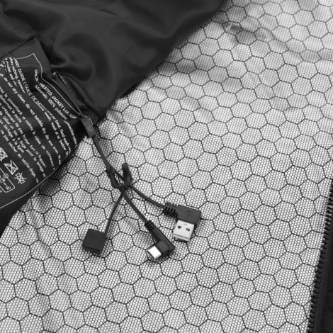 Gros plan sur la doublure intérieure à motif hexagonal gris et noir du gilet chauffant, avec une étiquette d'entretien noire et 