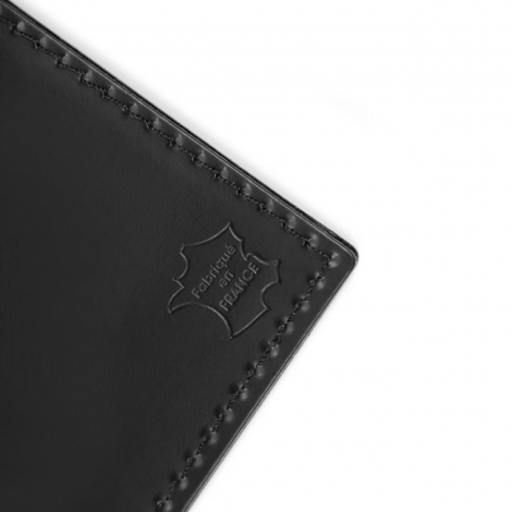 Détail des coutures et du marquage « Fabriqué en France » sur le porte-passeport noir.