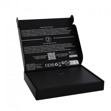 Porte-passeport noir présenté dans son coffret cadeau ouvert avec informations sur la carte de suivi intégrée.
