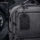 Étiquette de bagage noire personnalisée fixée à un sac de voyage gris. Étiquette de bagage noire personnalisée fixée à un sac de voyage gris.