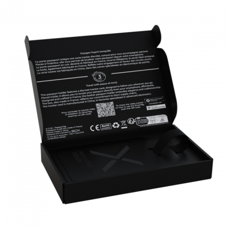 Étiquette de bagage noire avec carte de suivi présentée dans son coffret cadeau ouvert.