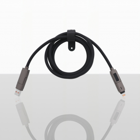 Câble de recharge multiconnecteur noir enroulé, présenté avec ses deux extrémités sur fond clair réfléchissant.