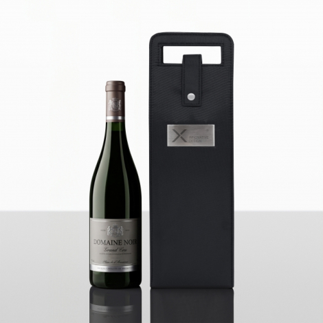 Sac porte-bouteille noir présenté de face à côté d'une bouteille de vin en verre vert foncé, avec poignée intégrée, fermeture à 