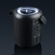 Enceinte Bluetooth noire photographiée de trois quarts sur fond sombre, avec grille textile tressée, boutons de commande, ports Enceinte Bluetooth noire photographiée de trois quarts sur fond sombre, avec grille textile tressée, boutons de commande, ports