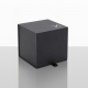Vue de trois quarts d'un coffret cadeau noir cubique fermé, avec surface mate, marquage blanc discret dans un angle du couvercle Vue de trois quarts d'un coffret cadeau noir cubique fermé, avec surface mate, marquage blanc discret dans un angle du couvercle