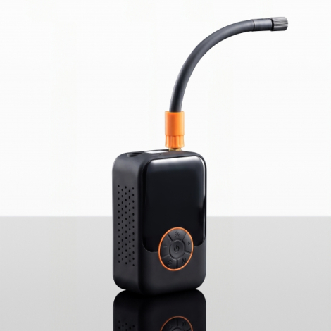 Vue de trois quarts d'un mini-compresseur électrique noir, avec flexible de gonflage courbé fixé sur le dessus par un raccord or