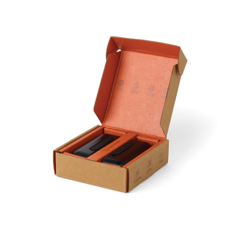 Coffret en carton kraft ouvert, avec intérieur orange et deux chauffe-mains noirs disposés côte à côte dans leur logement.