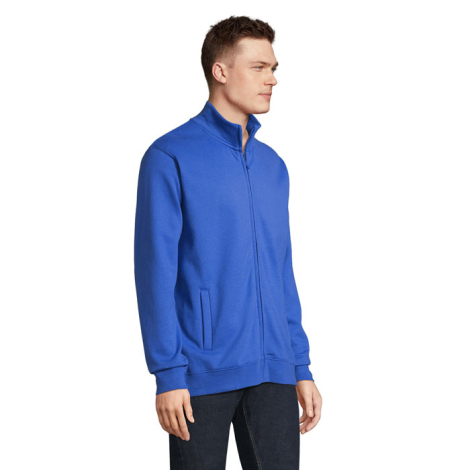 Mannequin homme présenté de trois-quarts, portant une veste zippée bleu royal à col montant légèrement ouvert. La coupe droite, 