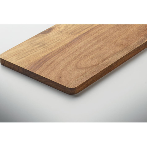 Vue rapprochée d’un angle de la planche à découper en acacia, mettant en évidence son épaisseur, ses bords arrondis et les varia