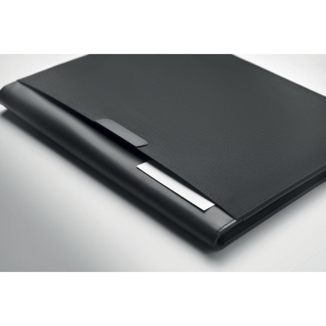 Gros plan sur la couverture noire texturée du conférencier, avec une petite languette et une plaque métallique argentée rectangu