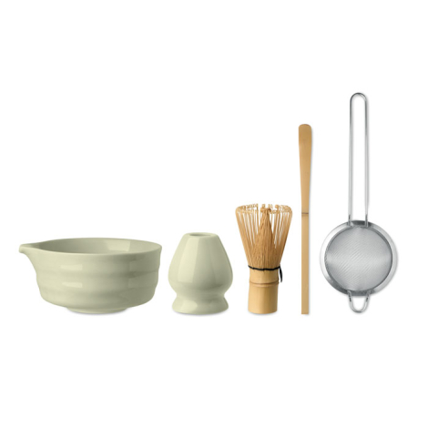 Présentation alignée des cinq accessoires du set à matcha : bol en céramique vert pâle avec bec verseur, support à fouet assorti