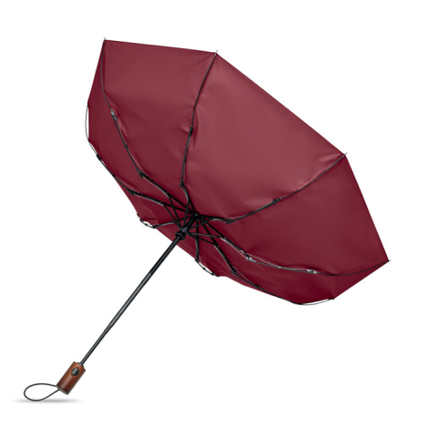 Vue de dessous d'un parapluie pliable bordeaux ouvert, montrant sa structure articulée noire, son manche et sa poignée en bois a