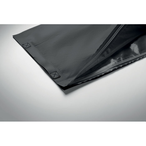 Vue rapprochée de l'ouverture du sac de compression noir, montrant sa double fermeture à glissière et sa poignée en sangle cousu