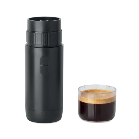 Machine à café portable noire avec module d'extraction apparent et boutons de commande en façade, présentée à côté d'une tasse t