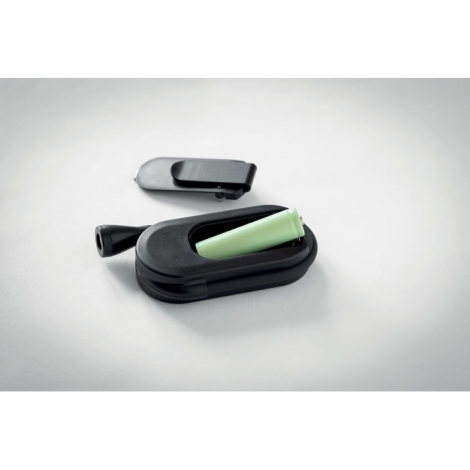 Lampe de lecture noire posée à plat, avec compartiment à batterie ouvert et couvercle à clip détaché au-dessus du boîtier. Une b