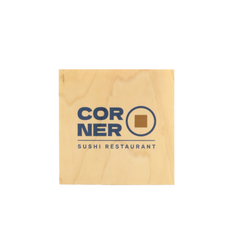 Sous-verre carré en bois blond, posé à plat sur fond blanc, avec veinage discret et personnalisation centrale composée de textes