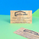 Deux cartes rectangulaires en bois clair avec logo et textes noirs. L'une est présentée verticalement, l'autre posée en diagonal Deux cartes rectangulaires en bois clair avec logo et textes noirs. L'une est présentée verticalement, l'autre posée en diagonal